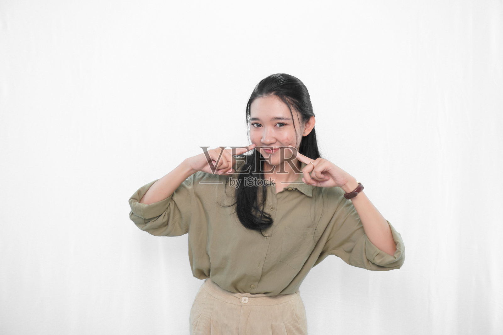 穿着绿色裙子的印尼亚洲女性在摄影棚中的表情照片摄影图片