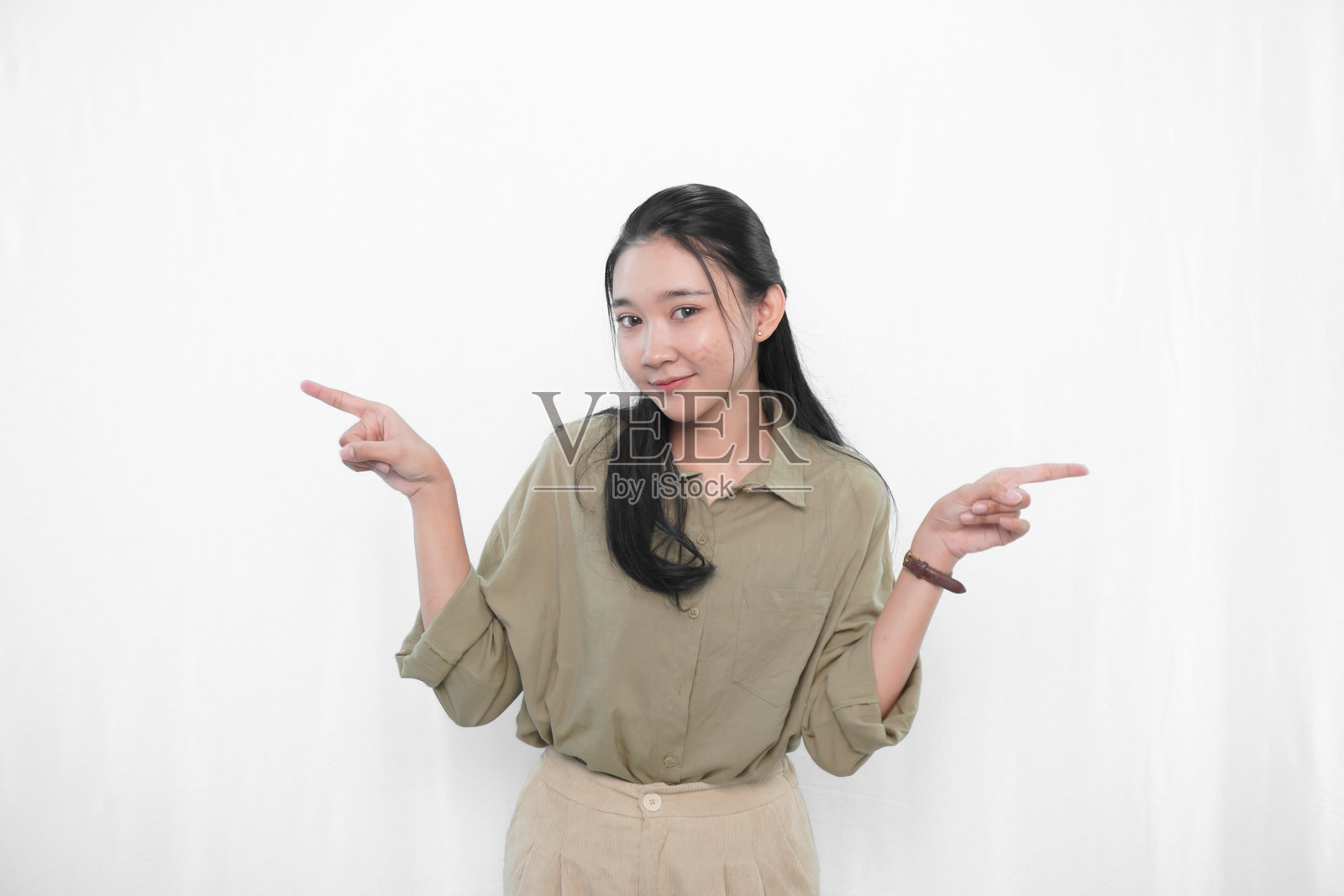 穿着绿色连衣裙的印尼亚洲女性在摄影棚中的表情照片摄影图片