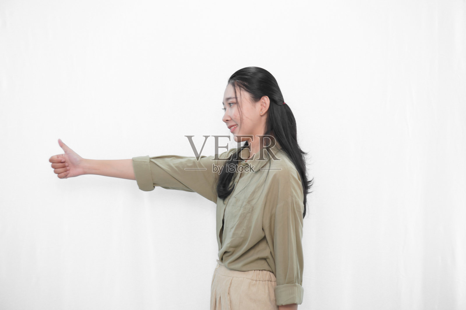 穿着绿色裙子的印尼亚洲女性在摄影棚中的表情照片摄影图片