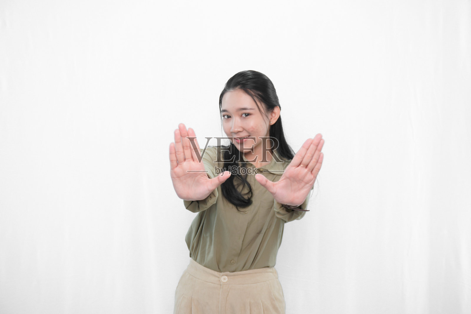 穿着绿色连衣裙的印尼亚洲女性在摄影棚中的表情照片摄影图片