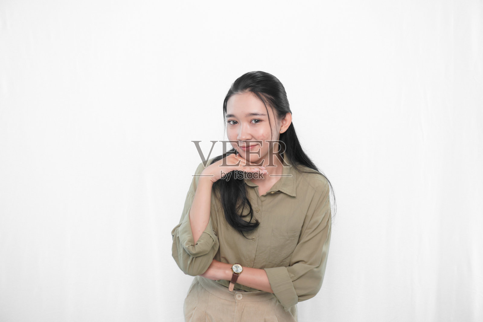 穿着绿色裙子的印尼亚洲女性在摄影棚中的表情照片摄影图片