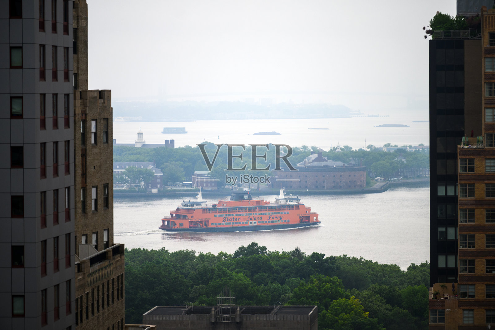 在纽约市中心高楼大厦之间的渡轮照片摄影图片