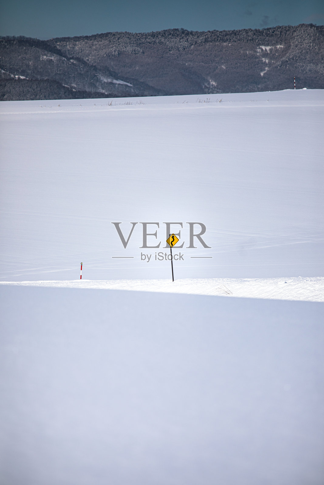 雪覆盖的田野上的黄色标志照片摄影图片