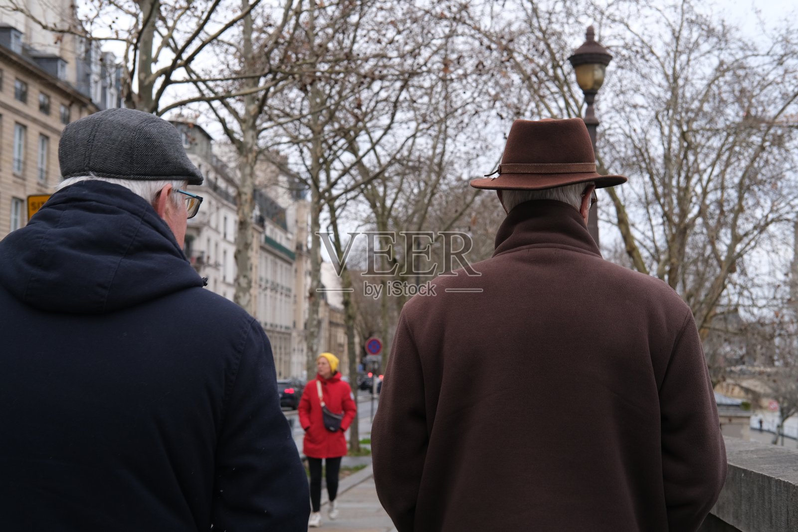 两位老巴黎人在塞纳河的码头上散步。照片摄影图片