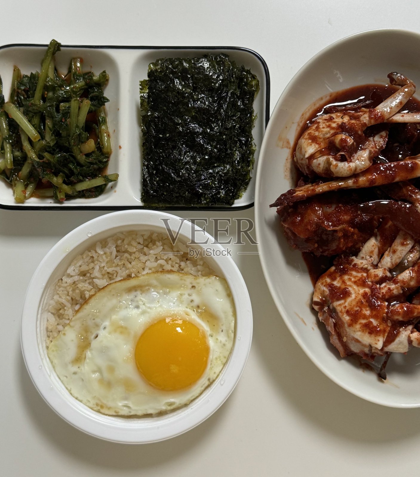 色彩丰富的韩国美食摆放在桌上，包含各种小菜（banchan），如泡菜、腌制蔬菜和调味绿叶菜。非常适合美食摄影，展示传统的韩国用餐文化。照片摄影图片