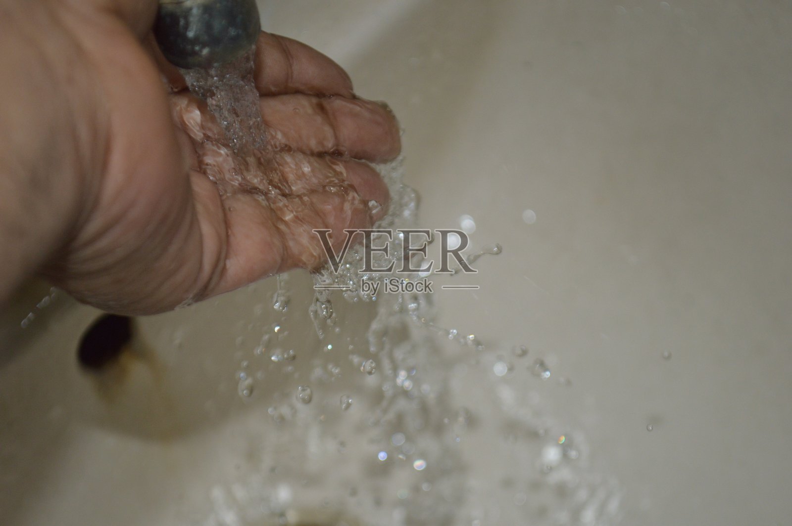 男子在水槽中洗手。浅景深。照片摄影图片