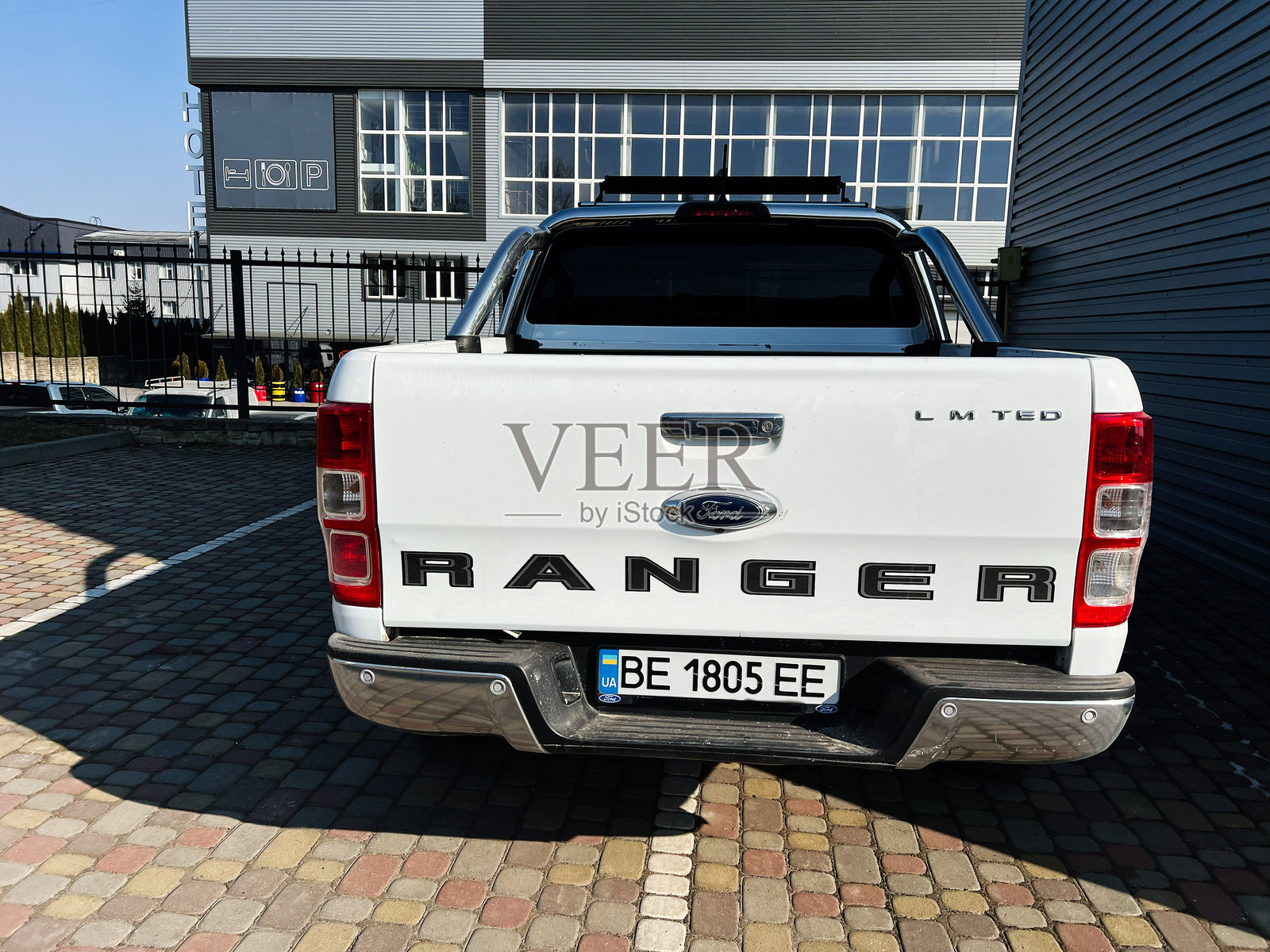 白色福特猛禽Ranger卡车的背面停在铺砌的户外停车场上照片摄影图片