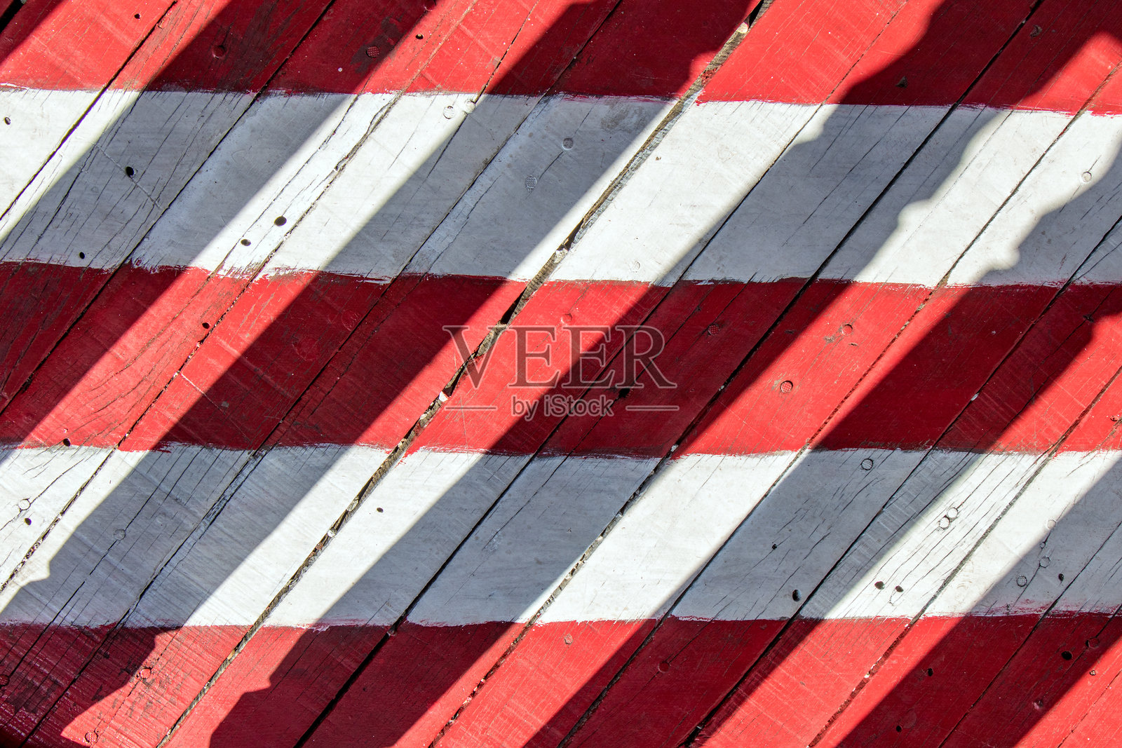 人行桥上的红白条纹。户外阳台上的木地板。照片摄影图片