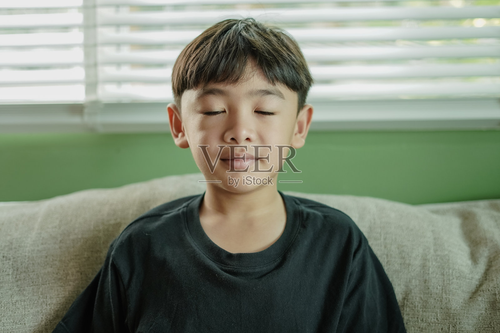 沙发上亚洲男孩的特写肖像照片摄影图片