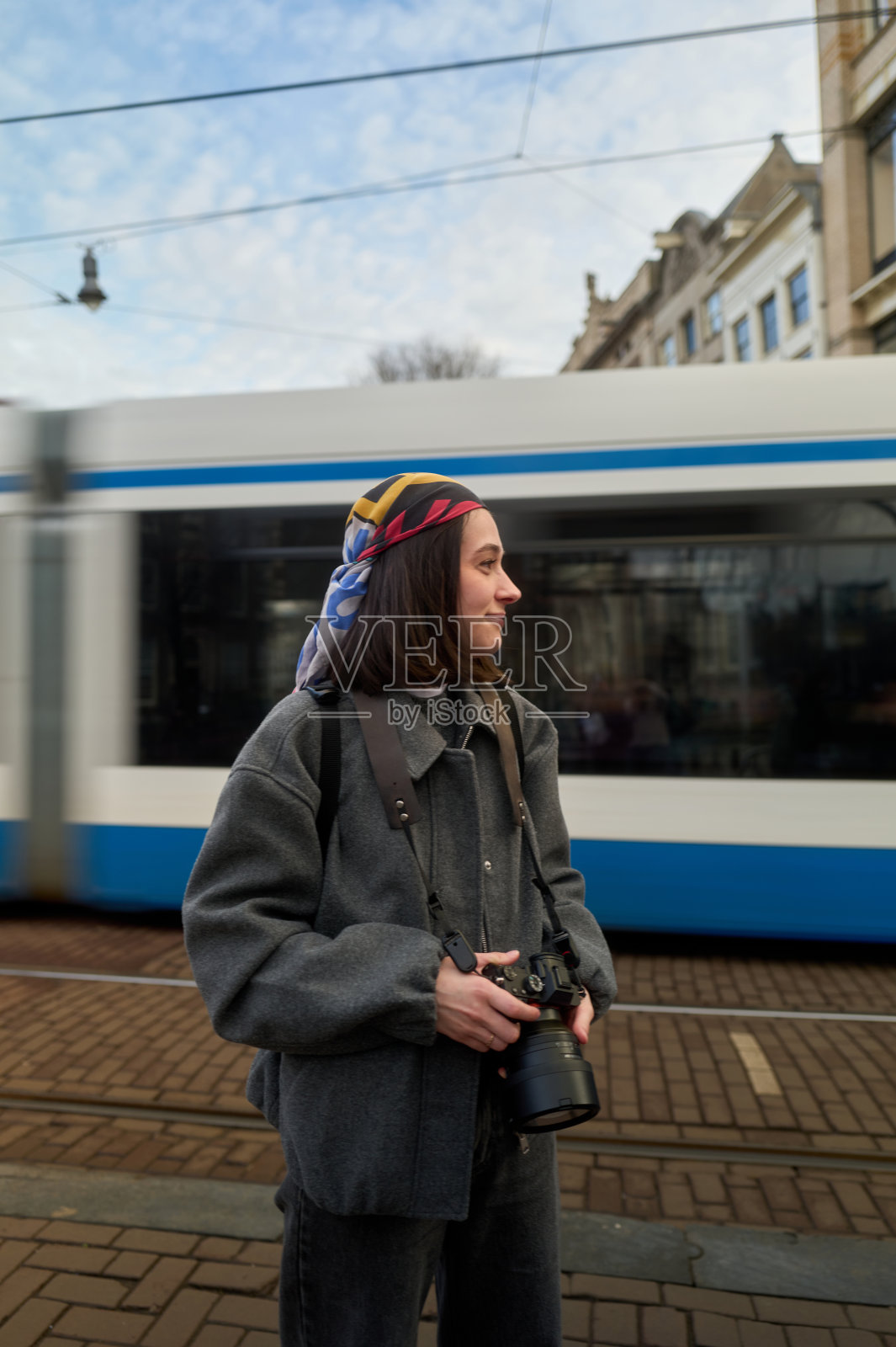 年轻摄影师在阿姆斯特丹等电车照片摄影图片