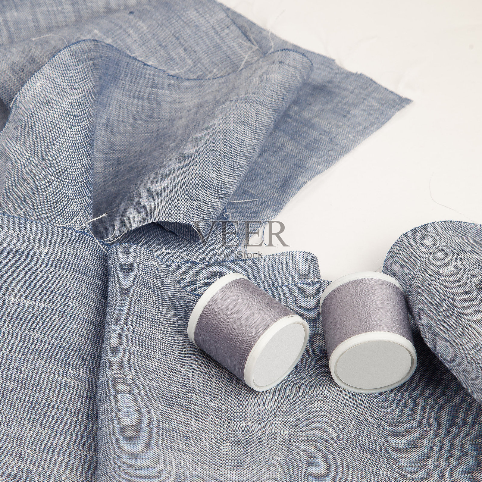 蓝色布料与缝纫线卷照片摄影图片