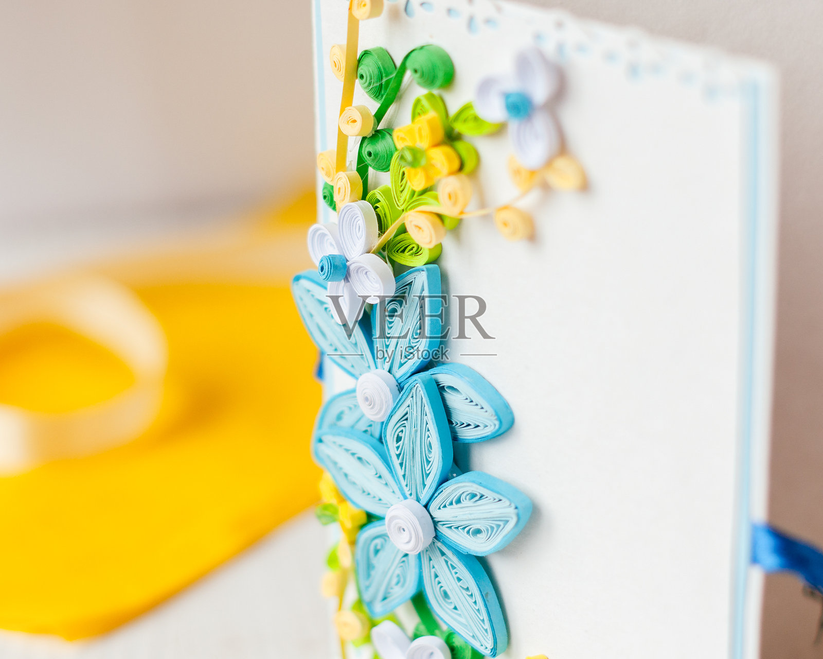 用彩色纸制作的纸质卷边花朵，装饰在白色卡纸卡片上。手工制作的卡片。纸花。彩色纸可以制作什么。照片摄影图片