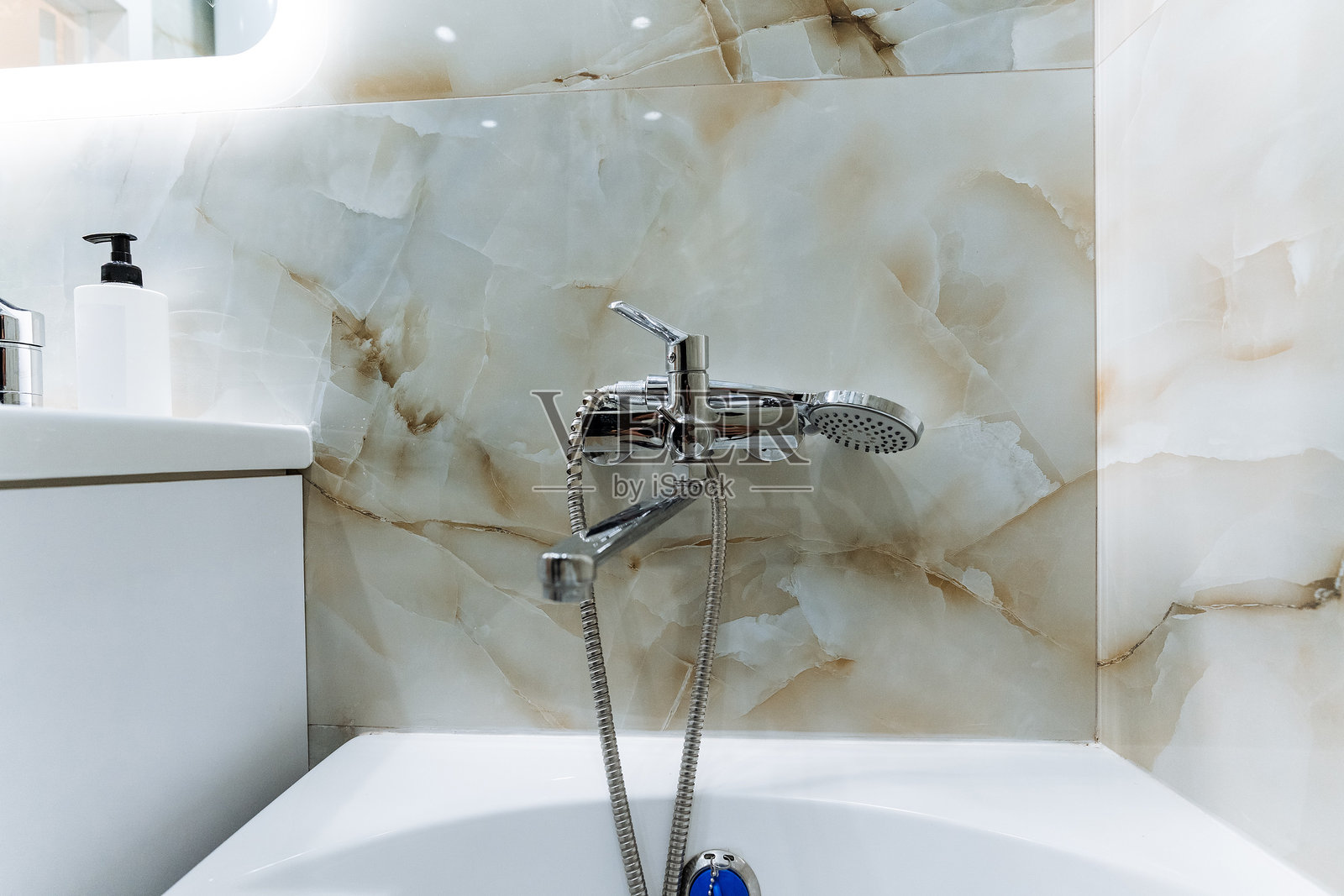 浴室配备了基本的管道设施，包括浴缸、洗手盆和马桶，使其成为一个功能齐全且舒适的个人卫生和放松空间。照片摄影图片