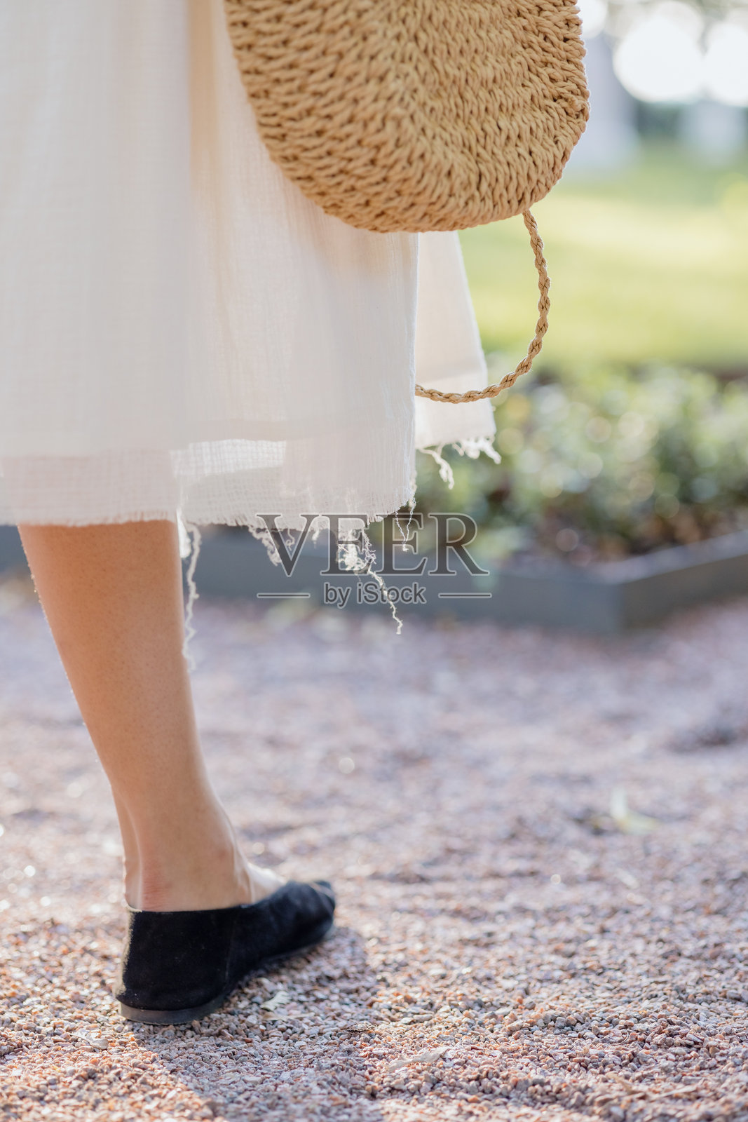 身穿白色连衣裙、戴着草帽和手提包的非裔美国女性特写，时尚模特搭配深色鞋子。照片摄影图片