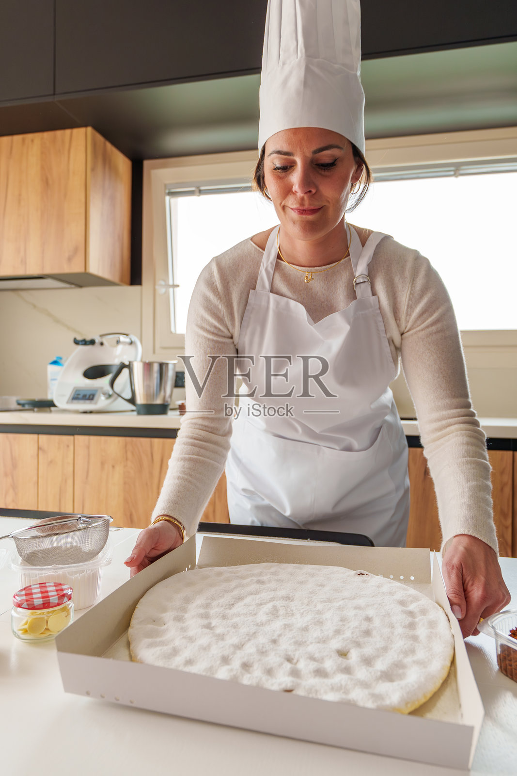 中年女性在现代厨房里烘焙蛋糕照片摄影图片