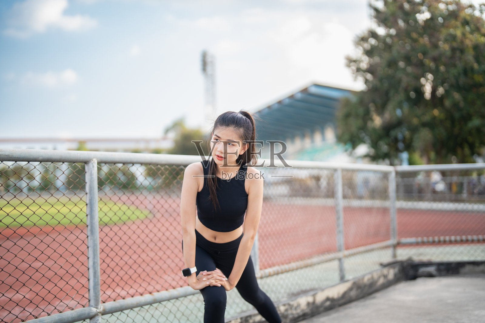 活跃健康的亚洲女性在早晨的体育场跑步锻炼，体现了健康和福祉的理念照片摄影图片