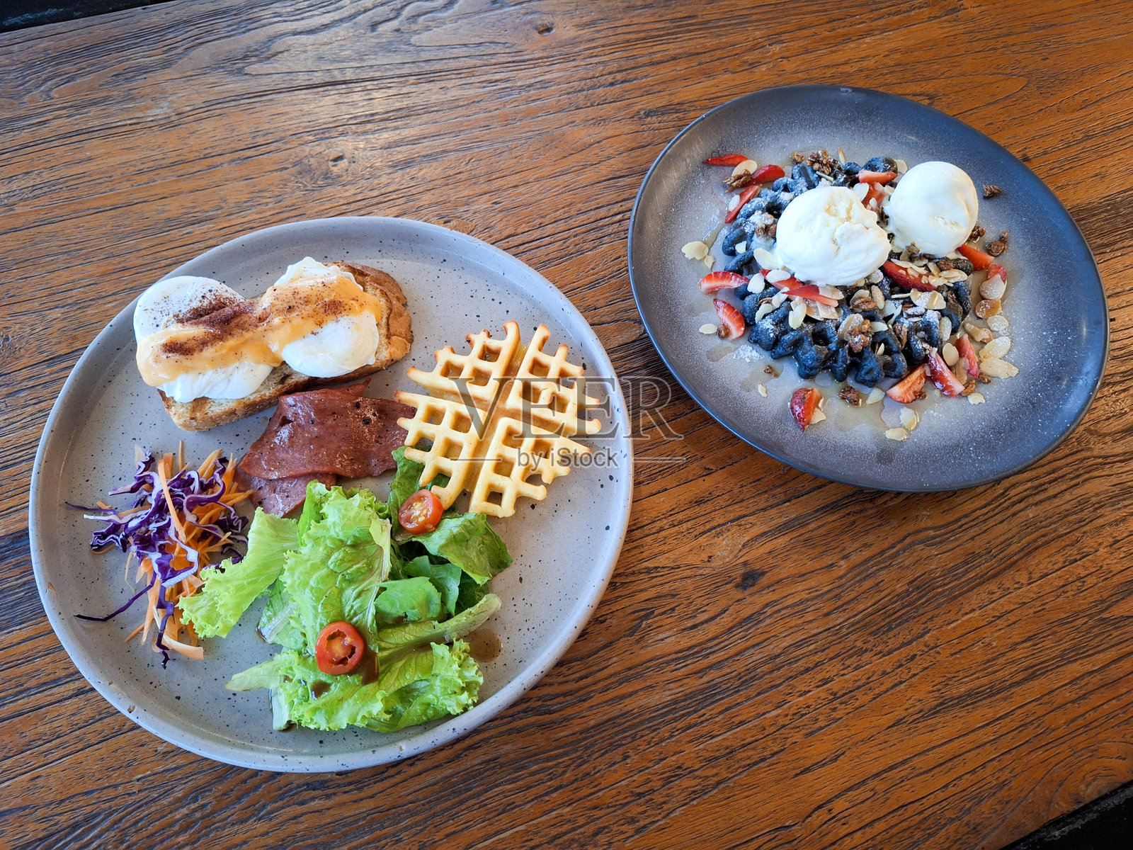 班尼迪克蛋配混合沙拉、夹心蛋糕或华夫饼、牛肉培根和牛肉鸡尾酒。黑色华夫饼上放有冰淇淋、格兰诺拉麦片和烤杏仁。甜点菜单。照片摄影图片