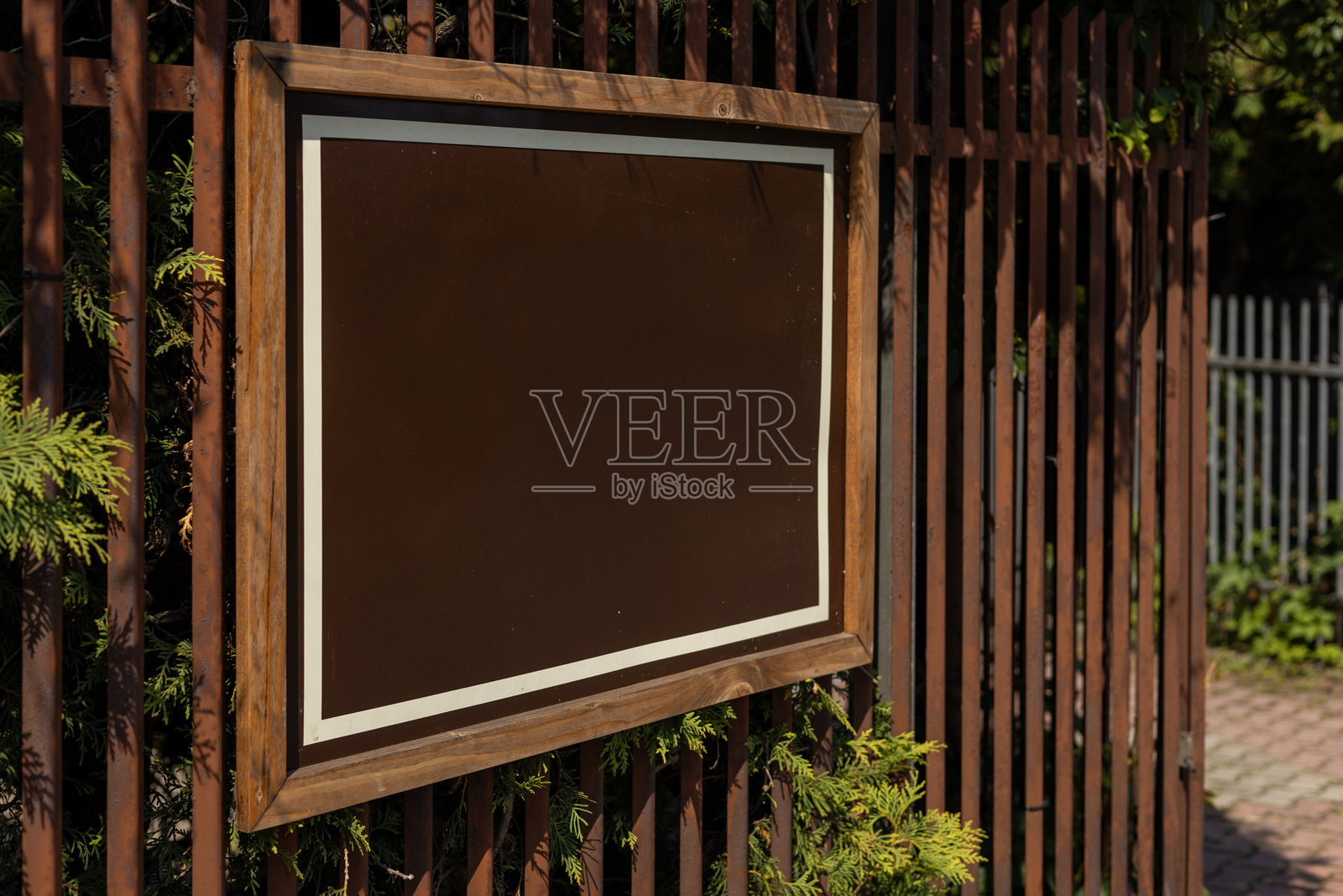 城市环境中的空白棕色广告牌模型。清晰的城市粘贴广告画布。钢铁围栏上的广告牌广告商。模型展示。照片摄影图片