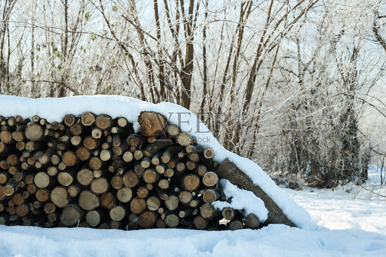 乡村冬季的照片，堆满雪的柴火准备为家庭取暖。照片摄影图片