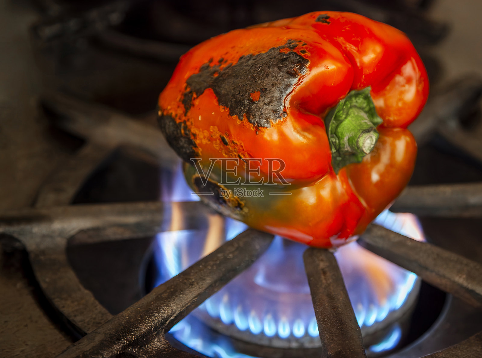 厨师在燃气灶上直接烤红椒照片摄影图片