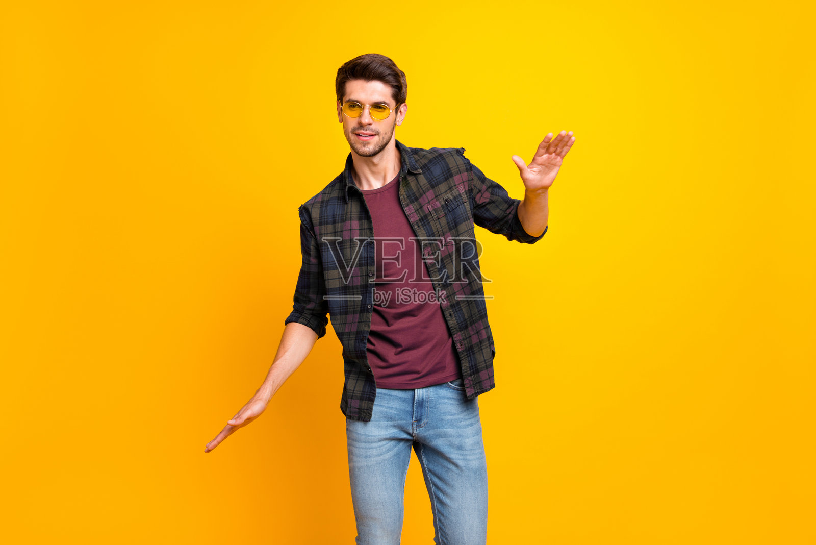 在色彩鲜艳的背景下，阳光明媚的男性们在夜总会中专注、愉快、放松地随着音乐节奏挥动手势。照片摄影图片