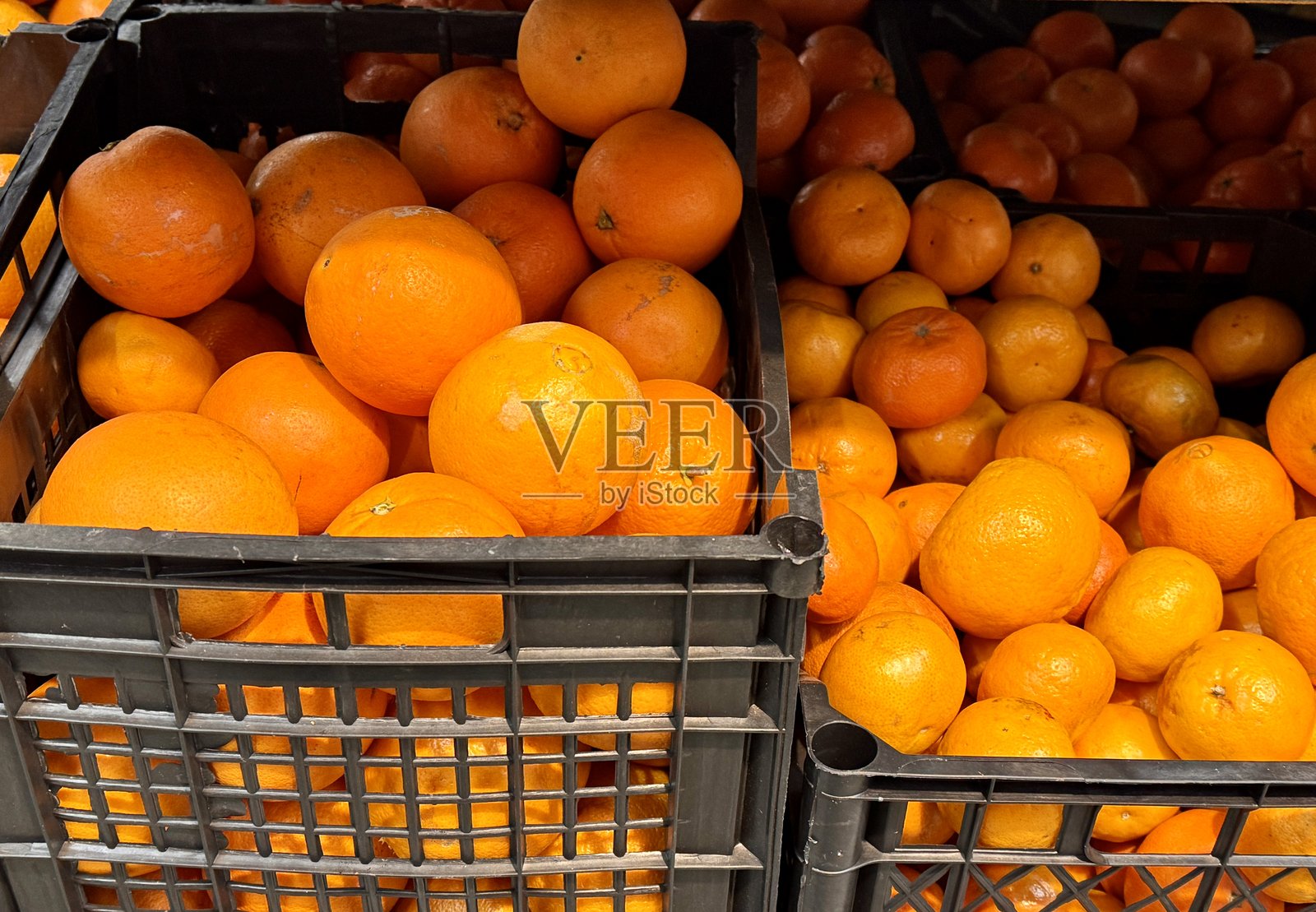 成熟的新鲜有机橙子在水果超市的货架上展示出售。照片摄影图片