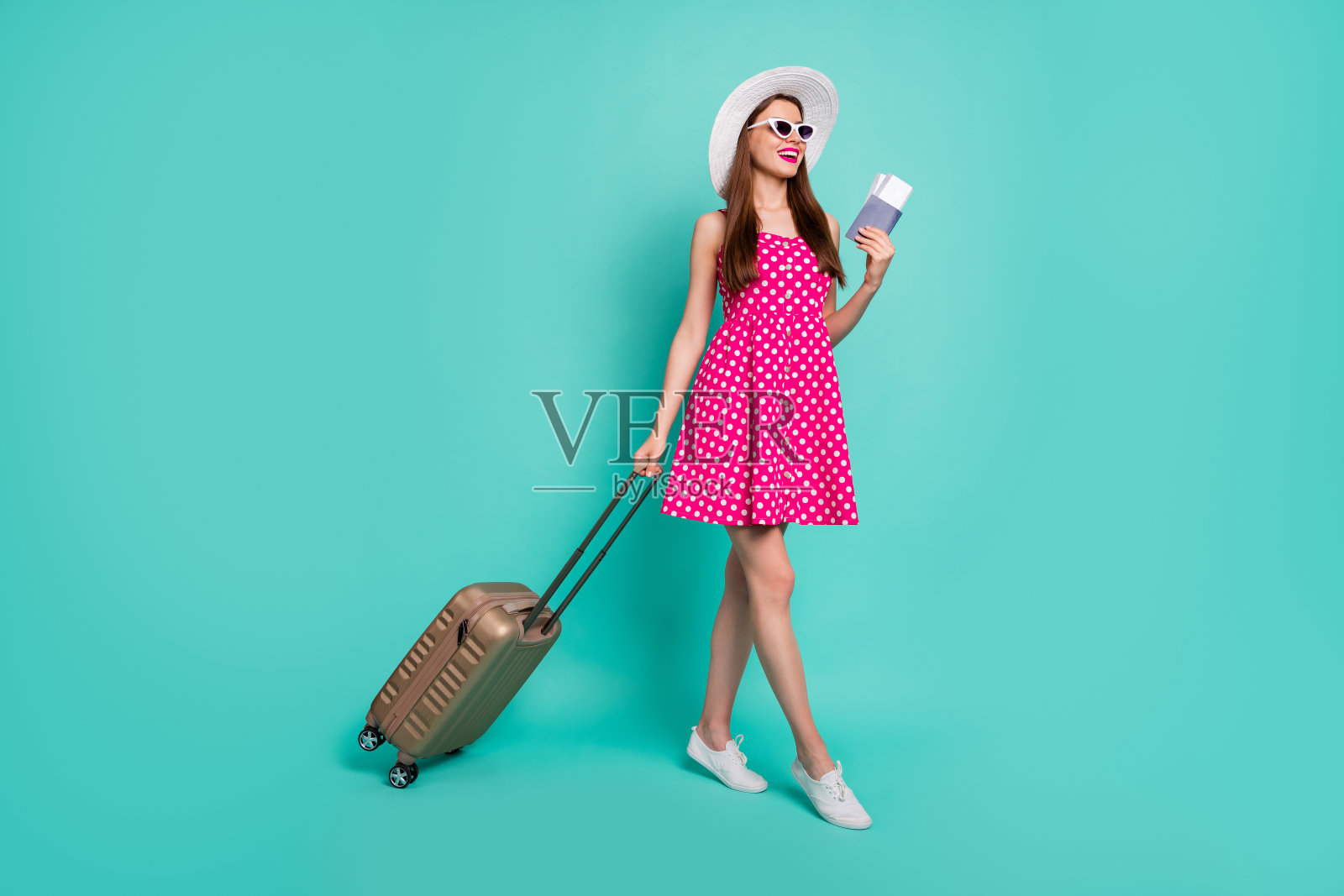 全身长像的漂亮迷人、愉快开心、梦幻般的直发女孩在国外火车站的出发到达，背景为明亮的绿色、蓝色和青色。照片摄影图片