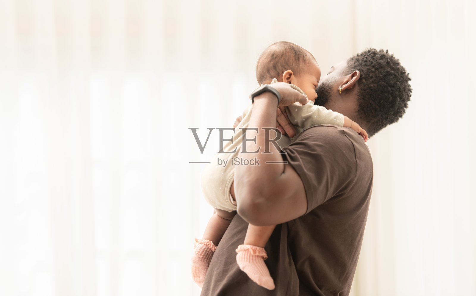 父亲抱着婴儿在怀中哄睡照片摄影图片