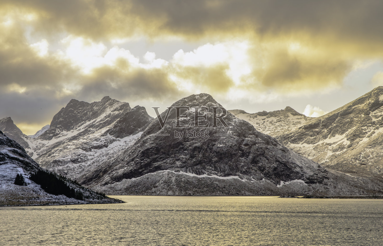 挪威洛弗敦群岛雪山上的金色北极光照片摄影图片