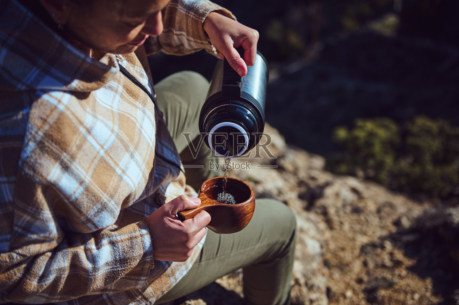 户外徒步探险中，近距离拍摄倒茶的人照片摄影图片