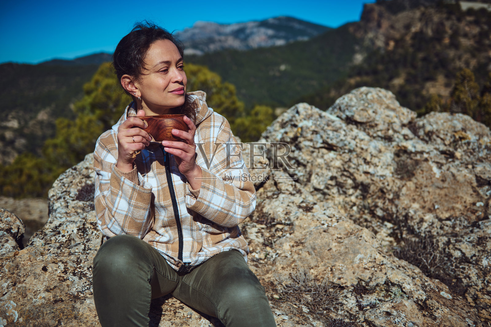 女性在风景如画的山间冒险中享受温暖饮品照片摄影图片