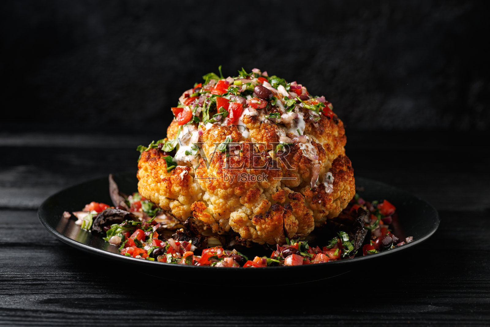 整颗烤花椰菜配新鲜莎莎酱和希腊酸奶酱。健康食品照片摄影图片