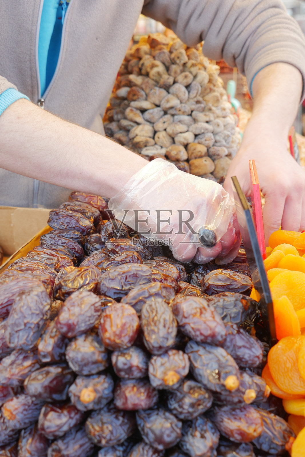 在摊位市场上仔细挑选各种干果用于烹饪照片摄影图片