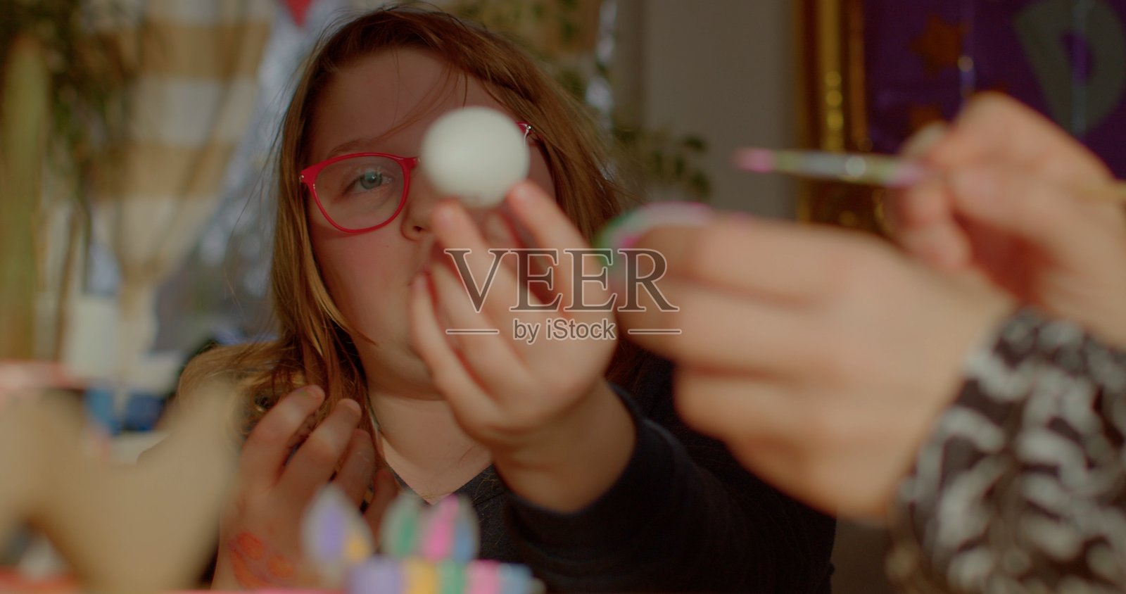 复活节彩蛋绘画。家人围坐在桌子旁，准备庆祝复活节。照片摄影图片
