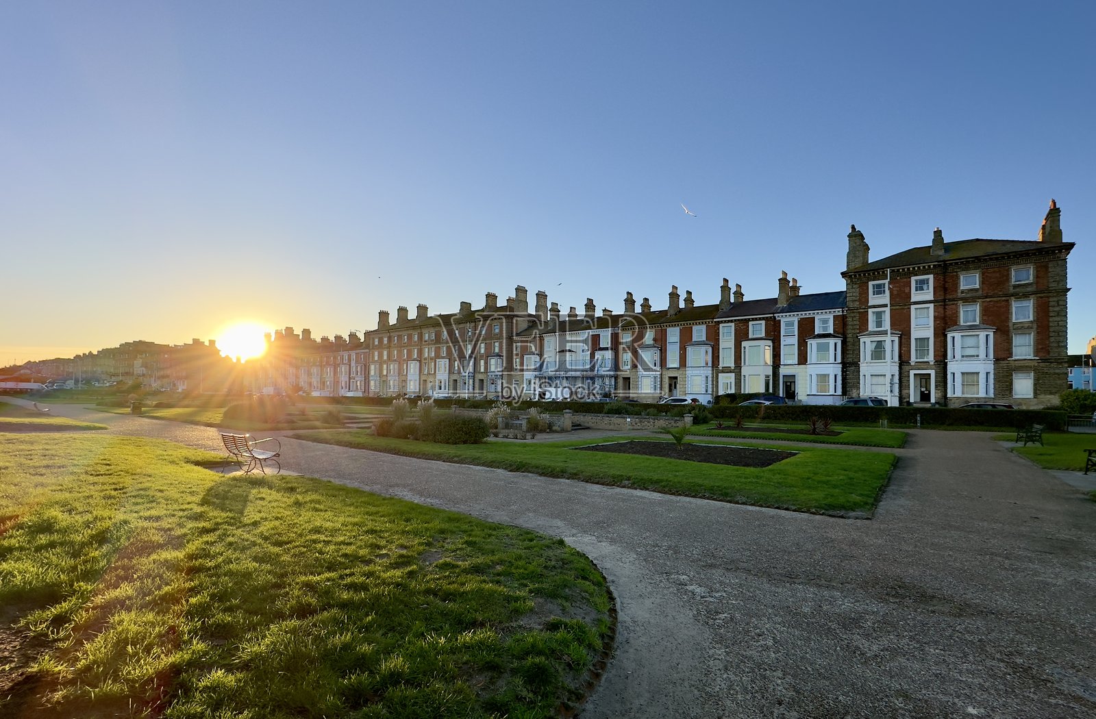 英国萨福克州洛韦斯托夫海滨的威灵顿滨海花园日落。照片摄影图片