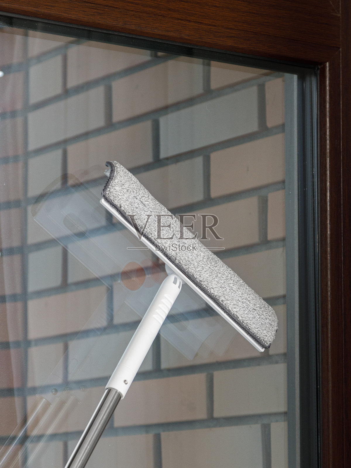 一个人正在仔细地用刮水器清洁窗户照片摄影图片