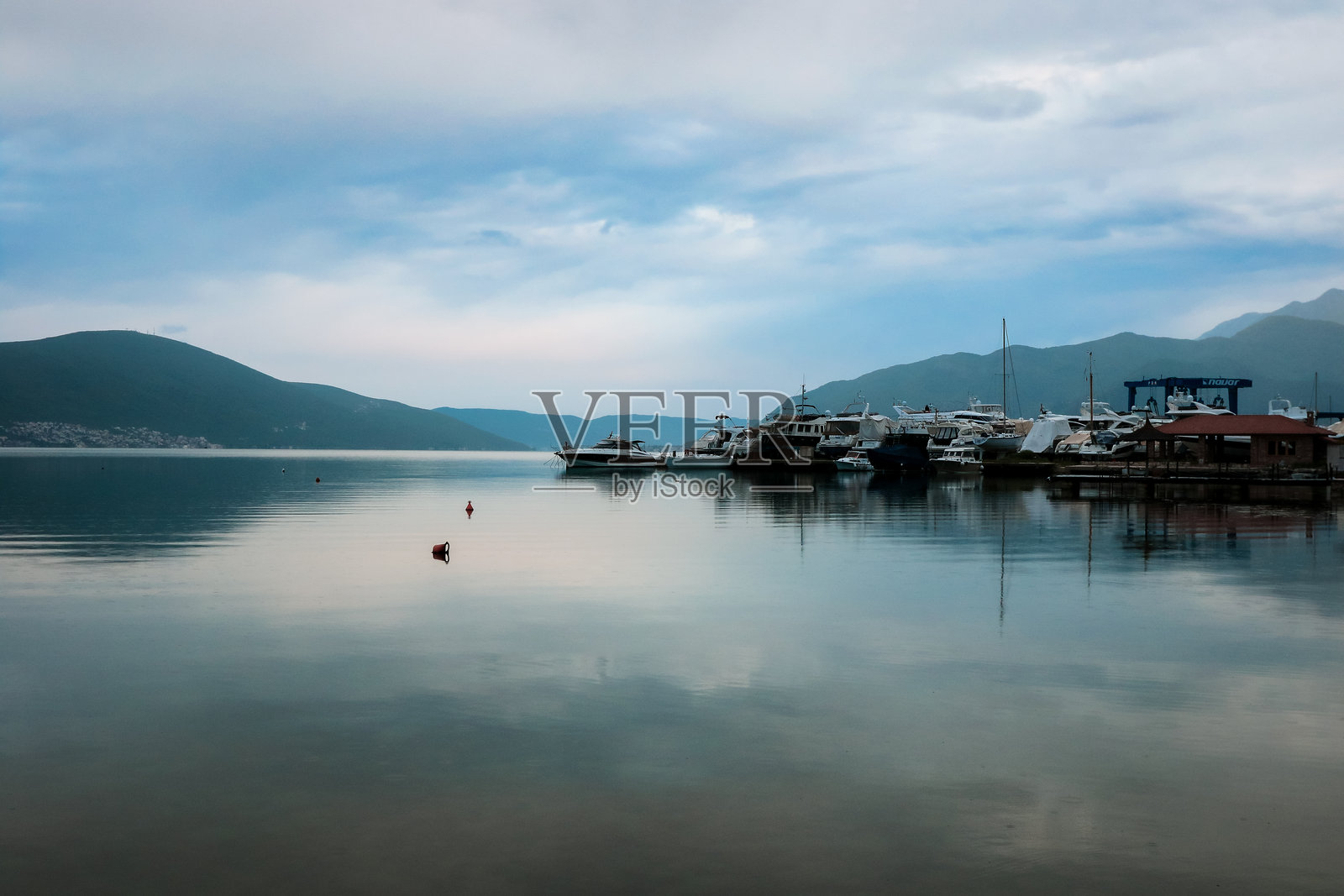 黑山巴尔城的平静水面上，船只在阴云天气中倒映。照片摄影图片