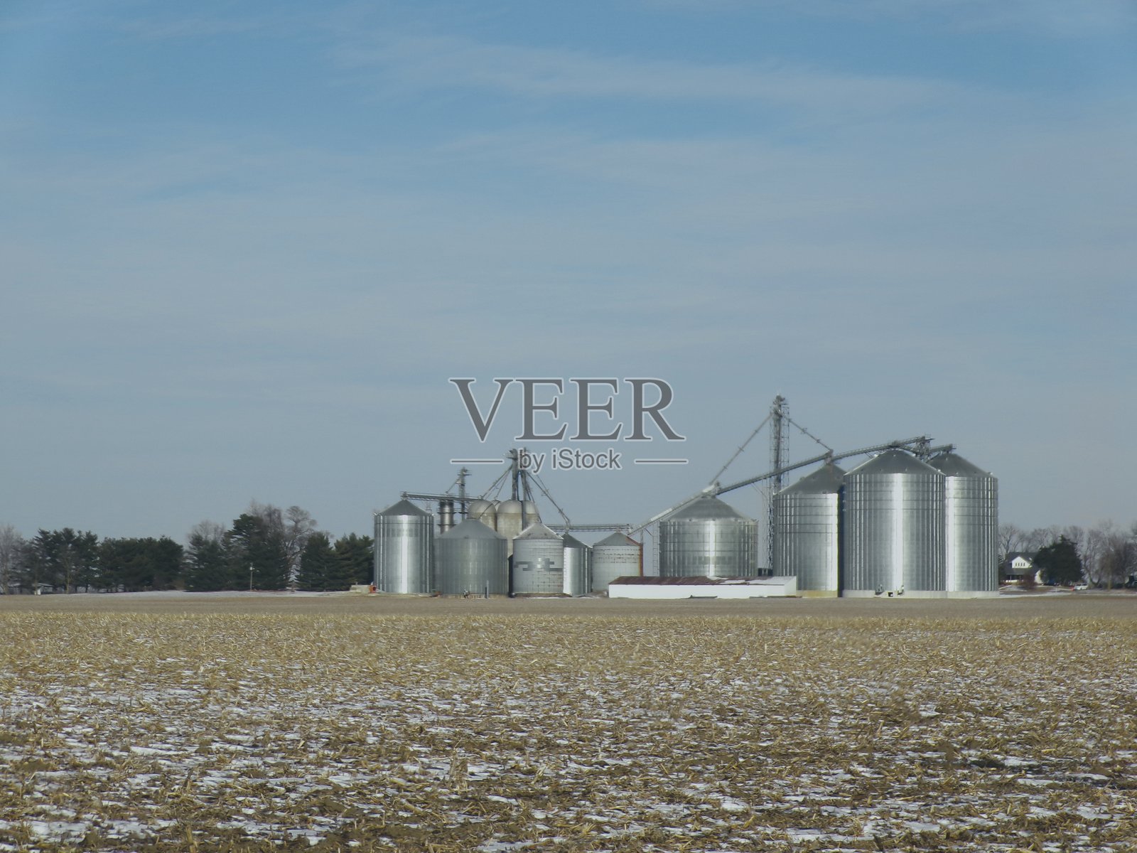 阳光明媚的日子里，蓝天上有田间的筒仓。照片摄影图片