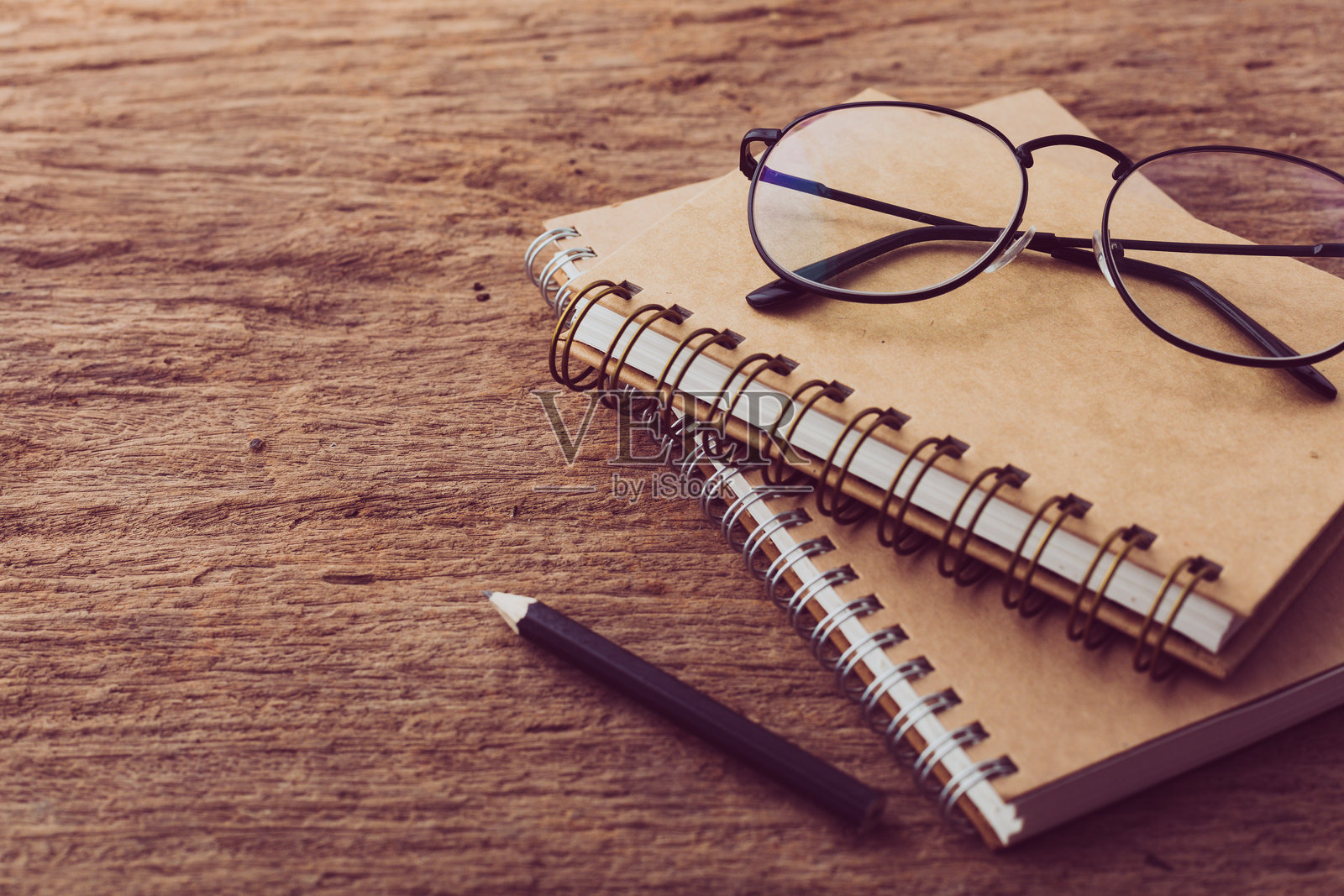木质背景上的笔记本、铅笔和眼镜照片摄影图片