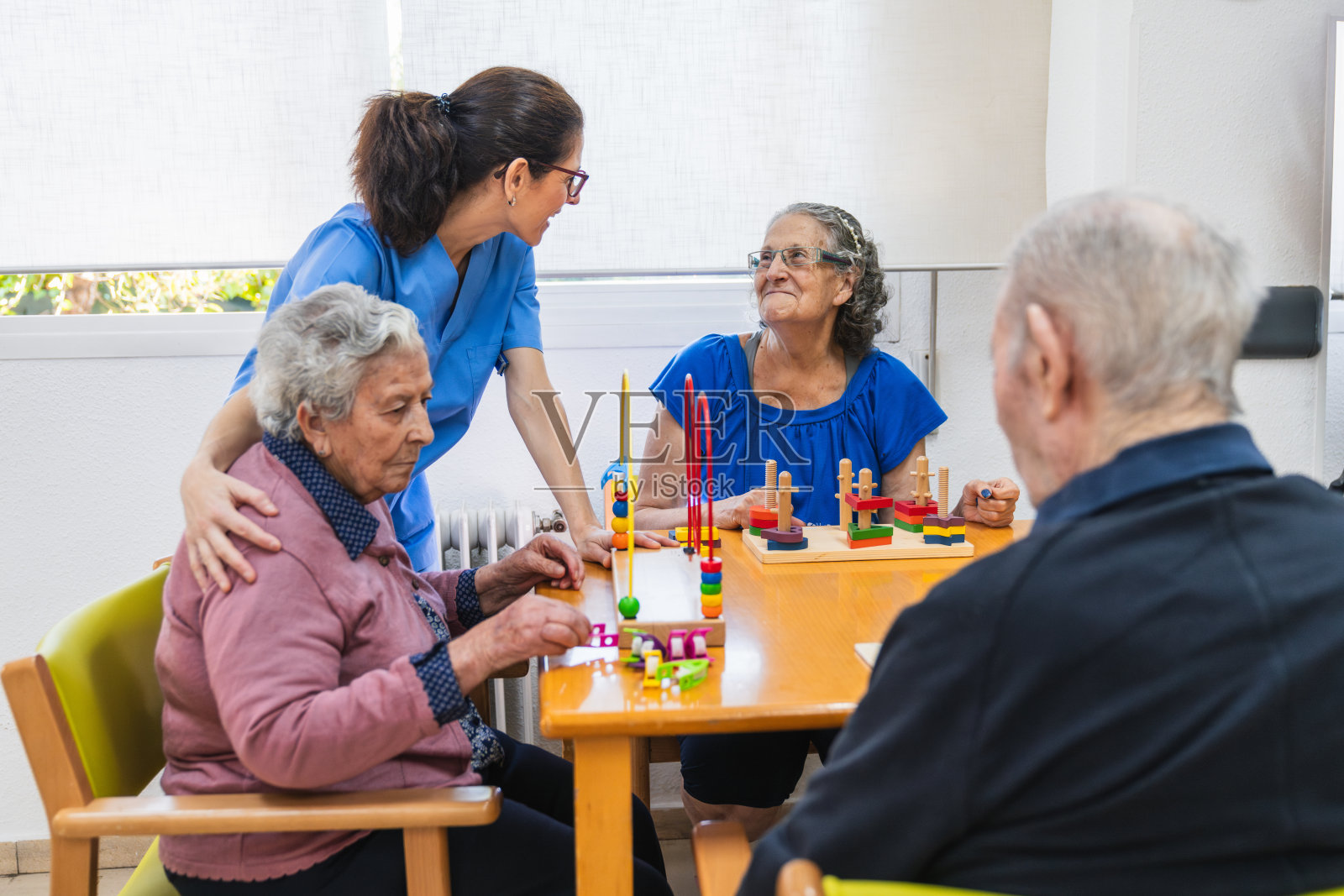 关心的护士与养老院的老人互动照片摄影图片