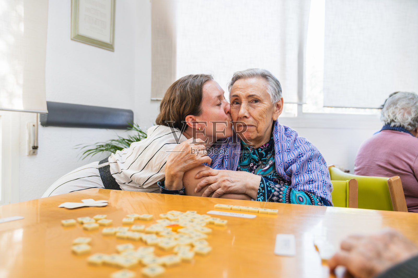 护士在养老院亲吻一位老年女性照片摄影图片