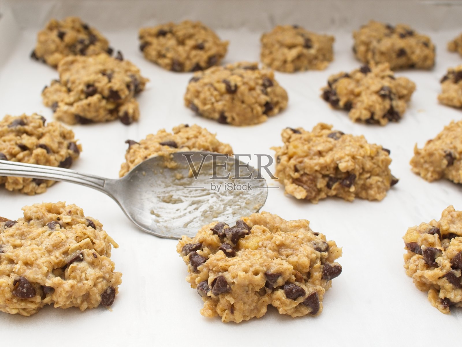 饼干面团被压在铺有烘焙纸的烤盘上照片摄影图片