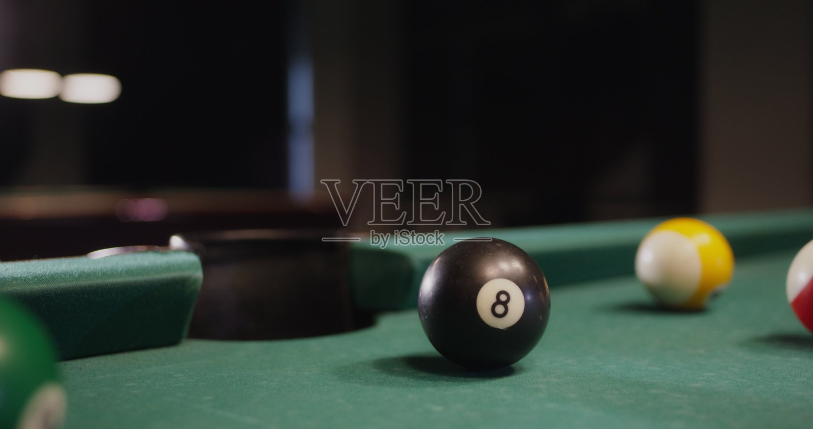 一颗台球飞入洞中，特写镜头。照片摄影图片