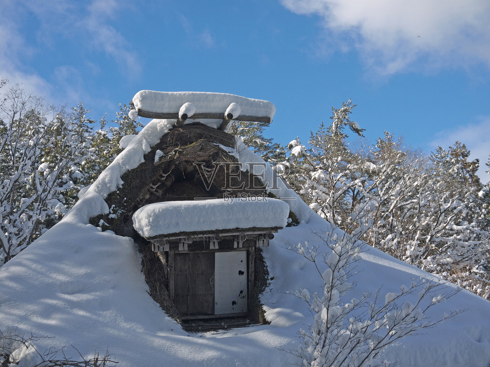 有雪堆的茅草屋照片摄影图片