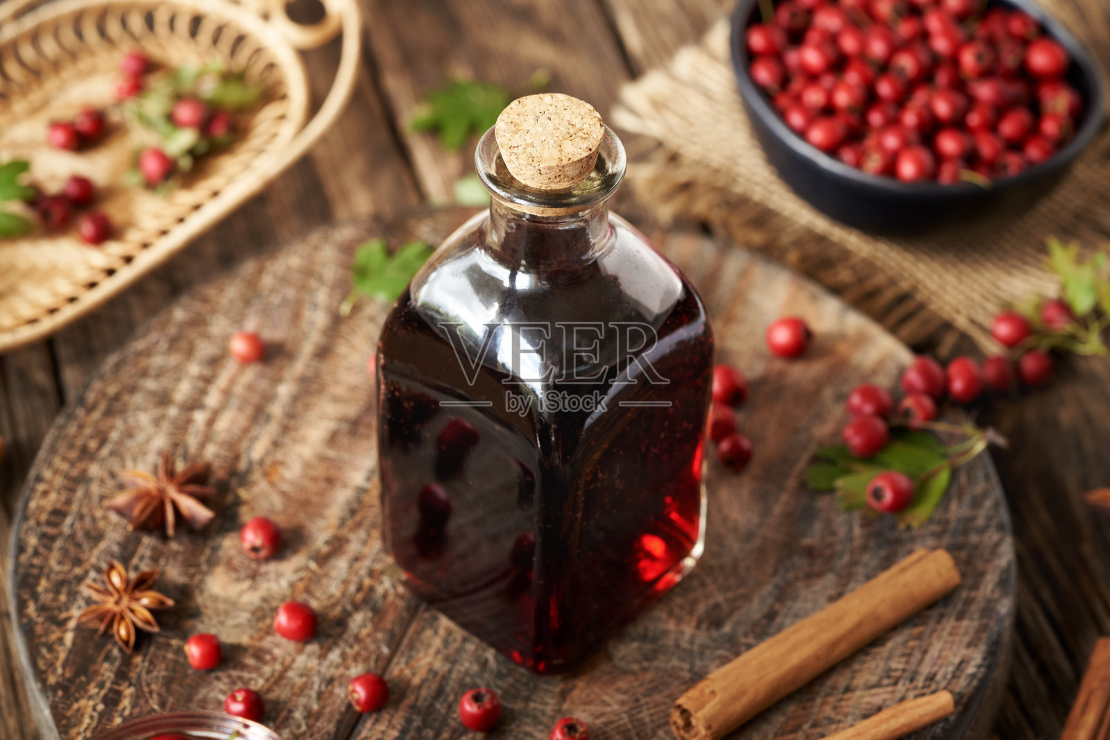 用新鲜山楂果酿制的药酒，盛在复古玻璃杯中照片摄影图片