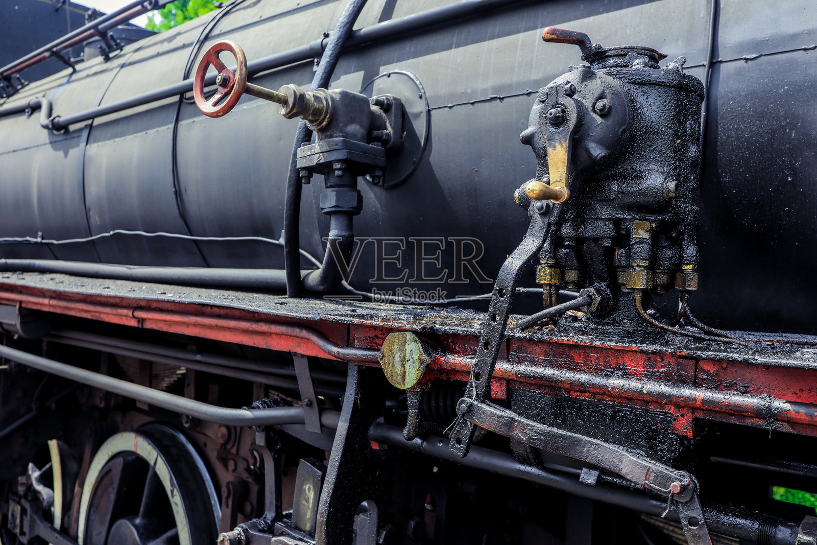 户外绿意盎然的环境中，复古蒸汽机部件的特写视图照片摄影图片