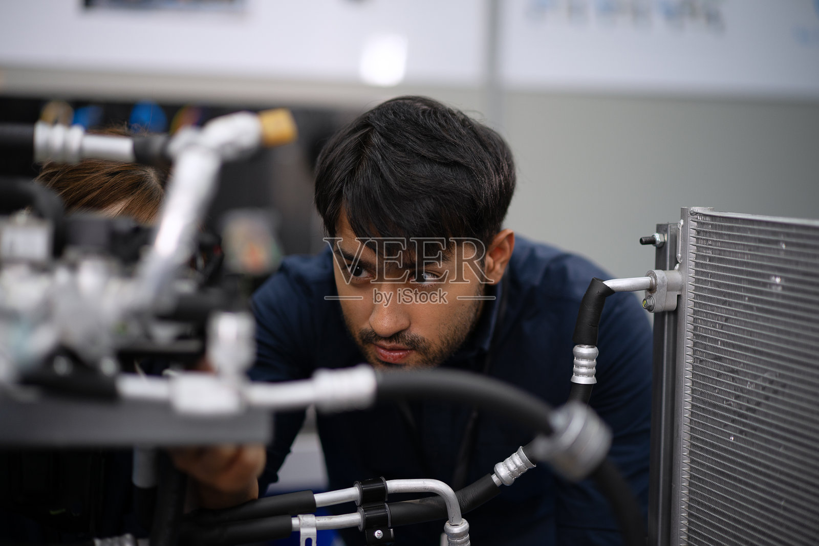 机械师在电动车维修车间工作。照片摄影图片