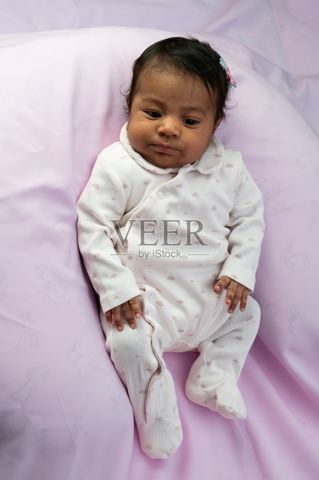 小女孩躺在紫色的床单上照片摄影图片