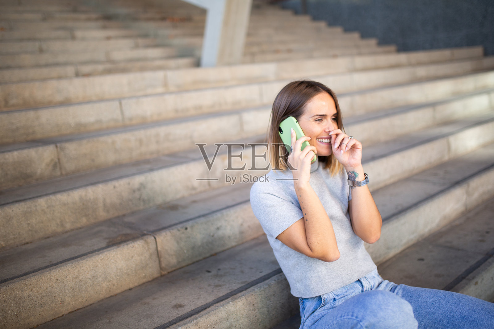 女人坐在楼梯上用手机交谈照片摄影图片