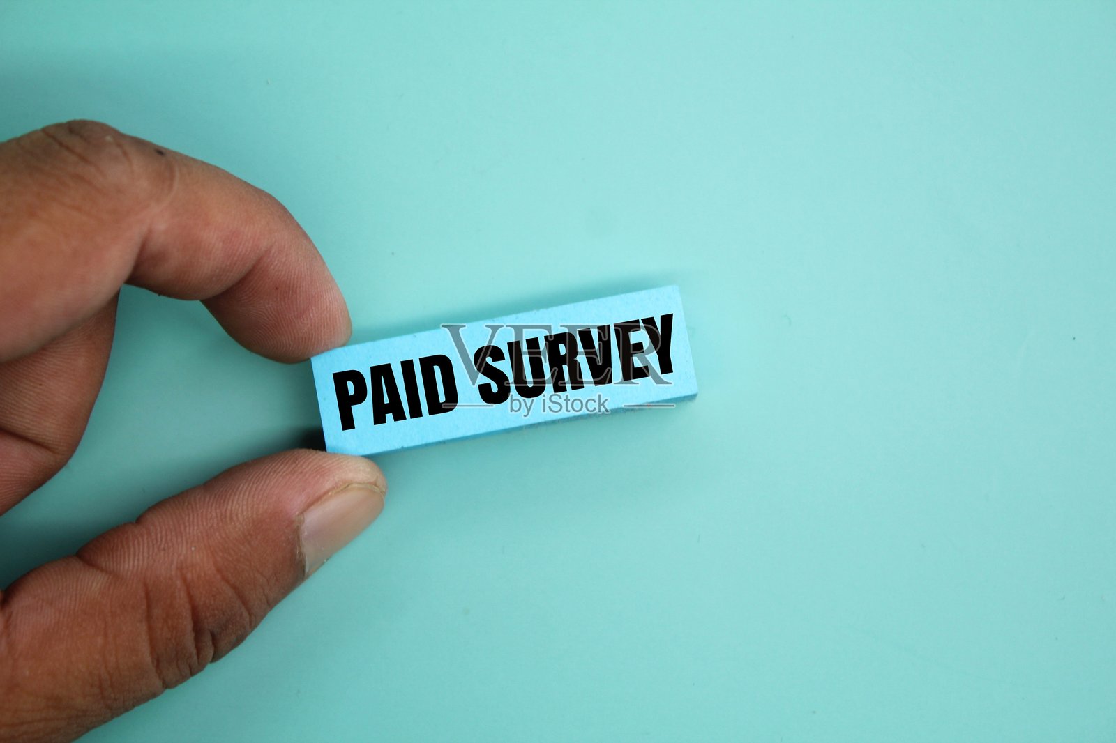 手握写有“付费调查”的彩色纸张照片摄影图片